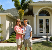 Family standing in front of house