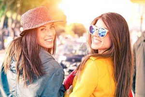 Two young women sitting together and smiling