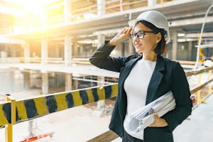 Professional woman holding building plans on a construction site