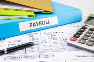 Payroll folder with time sheets and calculator