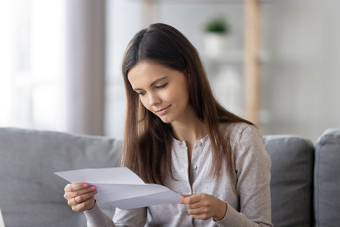 Girl reading a letter that provides her tax file number.