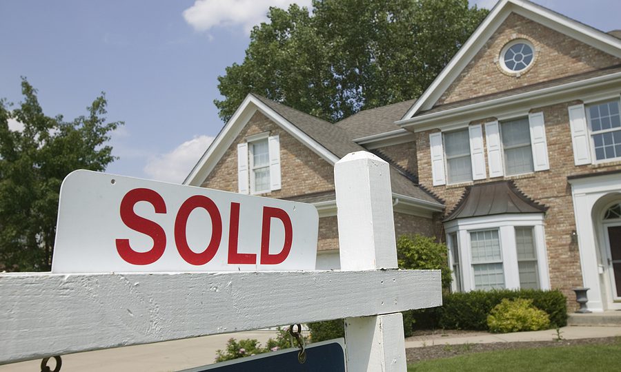 House with a sold sign in the front yard