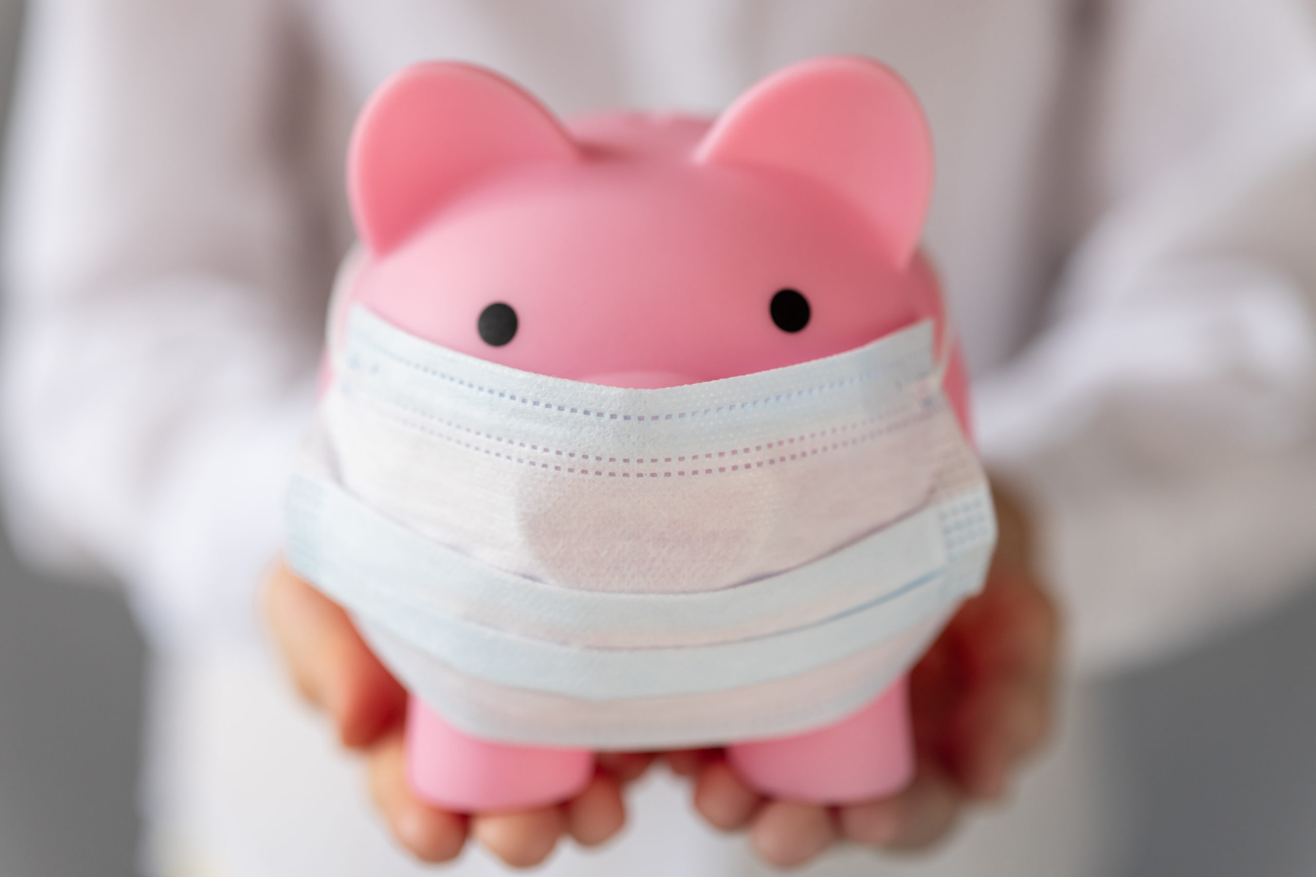 Piggybank wearing medical mask in children`s hands