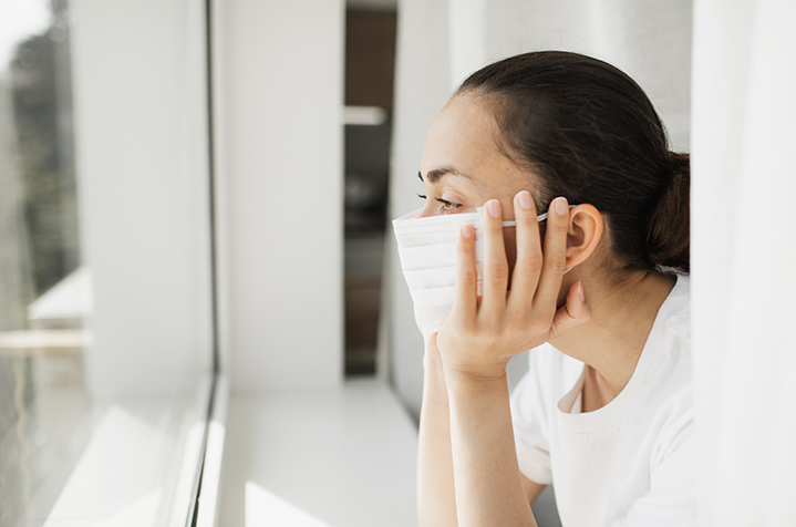 Woman with mask on in self isolation