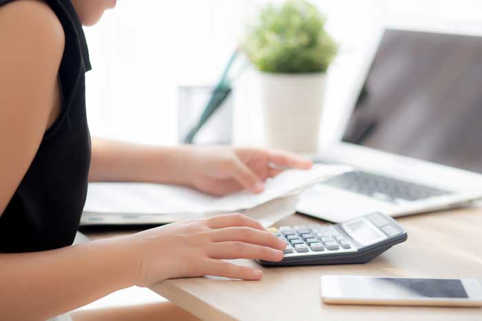 Person using a calculator at their desk