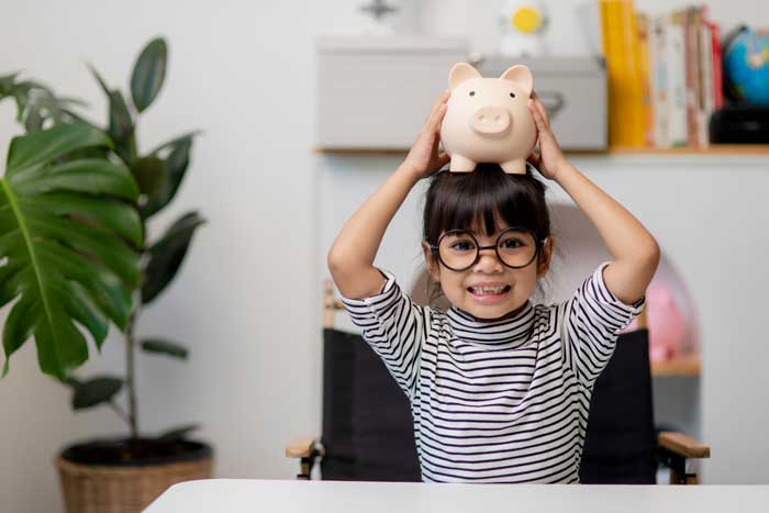 a child with piggy bank depicting the concept of teaching kids about money