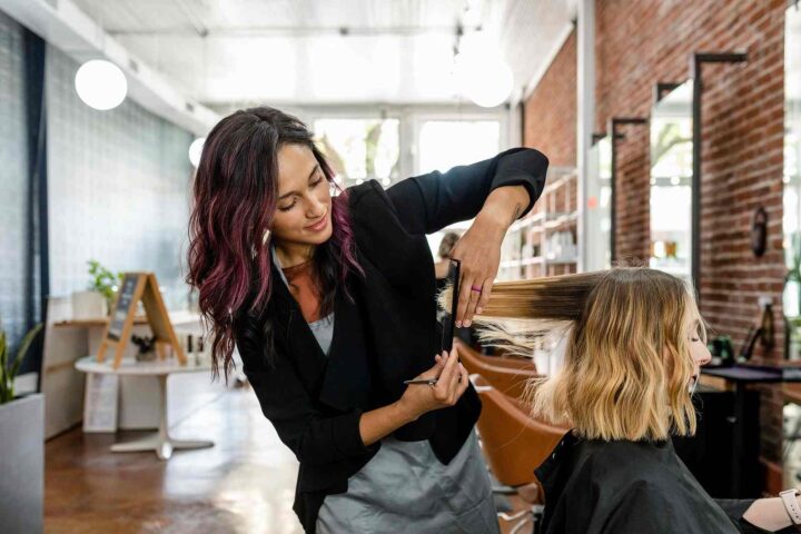Hairdresser cutting clients hair in a salon