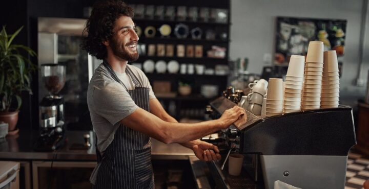 Young man working at a coffee machine